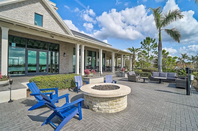 view of patio / terrace featuring french doors and an outdoor living space with a fire pit