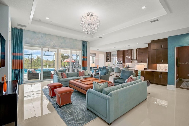 living area featuring light tile patterned floors, a raised ceiling, and visible vents