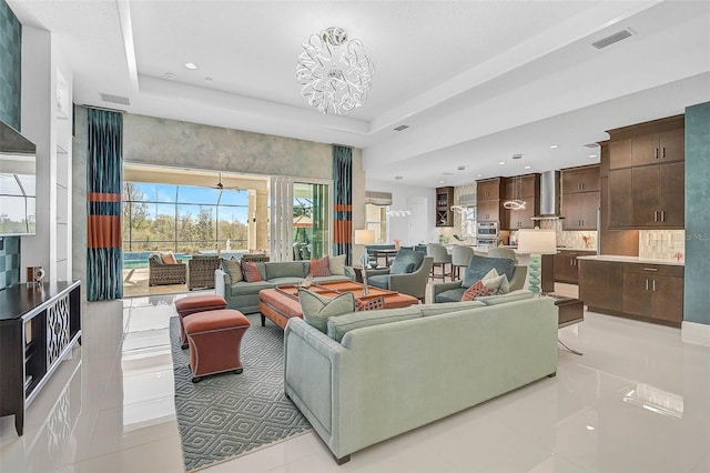 living area with light tile patterned floors, a tray ceiling, visible vents, and recessed lighting