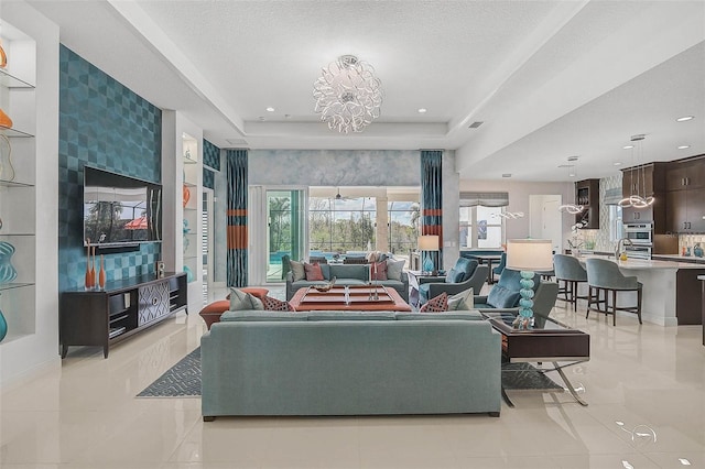 living area with a tray ceiling, light tile patterned flooring, recessed lighting, and an inviting chandelier