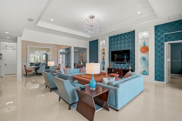 living area with a tray ceiling, light tile patterned flooring, visible vents, and built in features