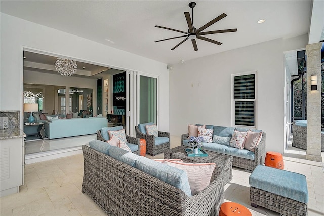 living area featuring stone tile floors, a ceiling fan, and recessed lighting