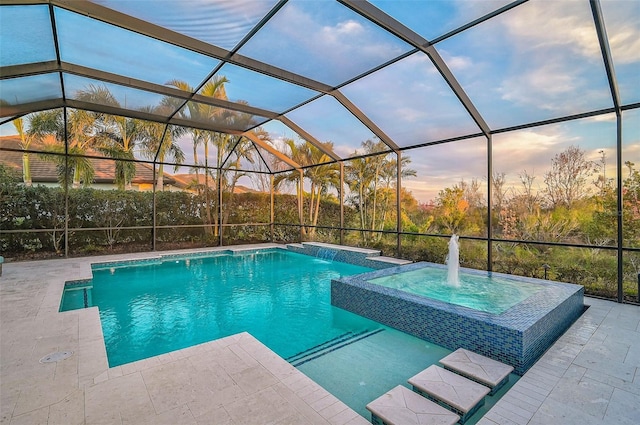 pool at dusk featuring an outdoor pool, glass enclosure, a patio area, and an in ground hot tub