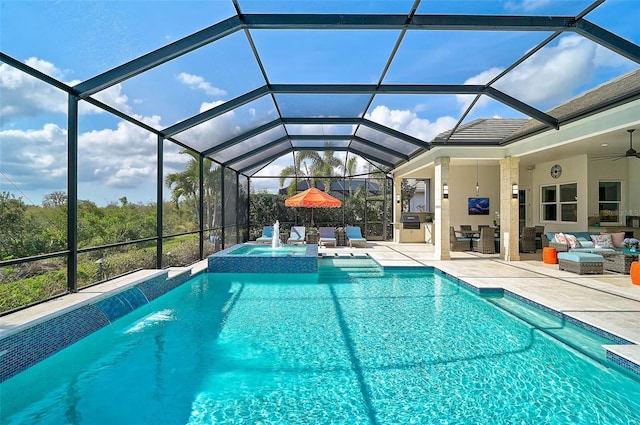 view of swimming pool with a pool with connected hot tub, an outdoor hangout area, a ceiling fan, a patio area, and glass enclosure