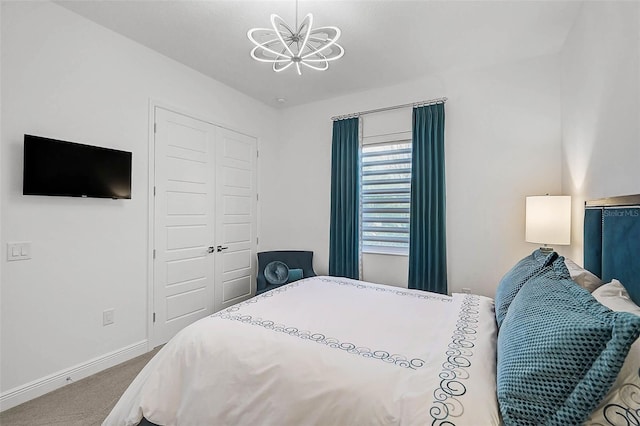 bedroom with a notable chandelier, a closet, baseboards, and carpet flooring