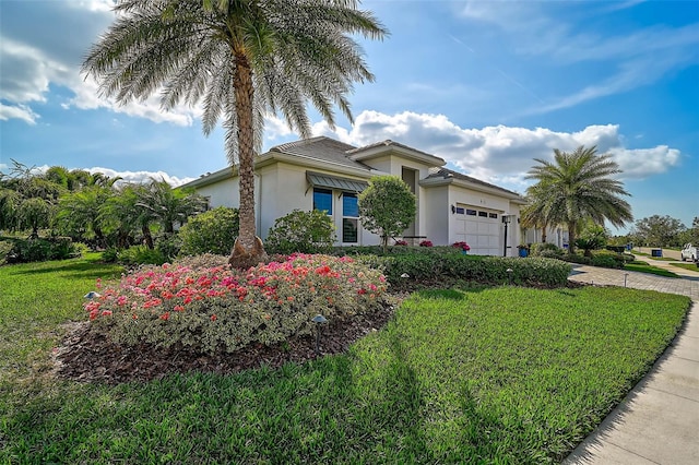 view of front of house featuring a garage, a front lawn, and stucco siding