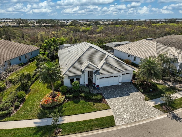 view of front facade with an attached garage, stucco siding, decorative driveway, and a tiled roof