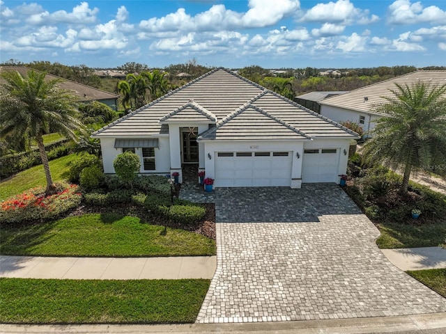 8261 Grande Shores Dr, Sarasota, FL 34240 - view of front of home with a garage, decorative driveway, stucco siding, and a tile roof