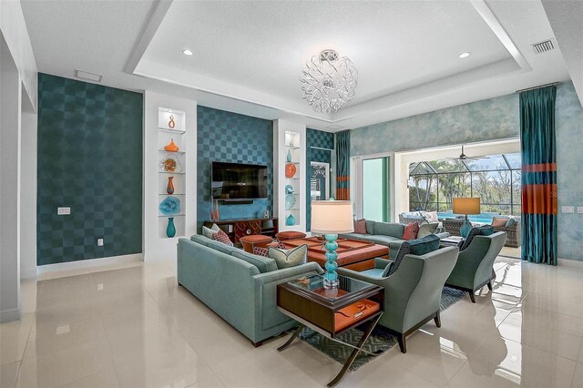 8261 Grande Shores Dr, Sarasota, FL 34240 - tiled living area featuring wallpapered walls, a tray ceiling, an accent wall, a chandelier, and recessed lighting