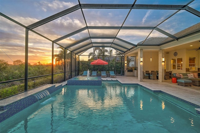 8261 Grande Shores Dr, Sarasota, FL 34240 - pool at dusk with a patio, a pool with connected hot tub, a lanai, a ceiling fan, and outdoor lounge area