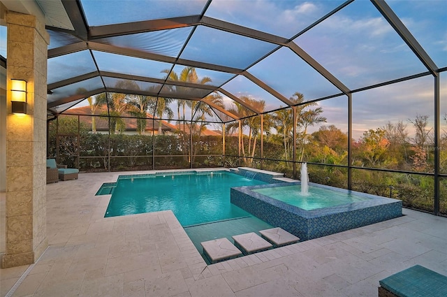 8261 Grande Shores Dr, Sarasota, FL 34240 - pool at dusk featuring a patio area, a pool with connected hot tub, and glass enclosure