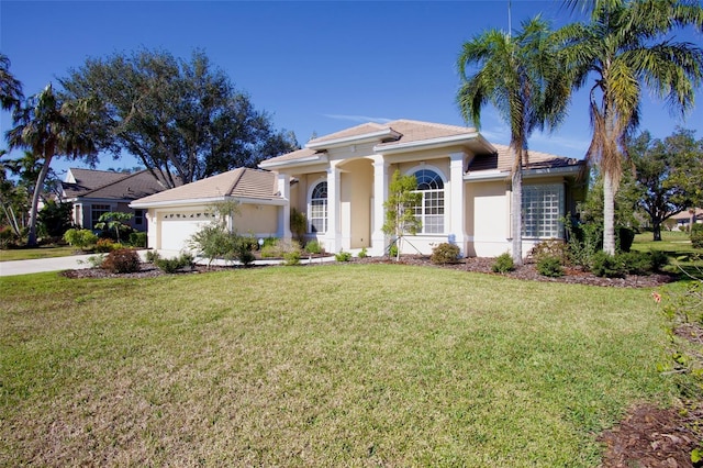 mediterranean / spanish-style home with a garage and a front lawn