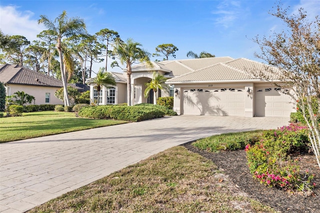 mediterranean / spanish-style home featuring a garage and a front yard