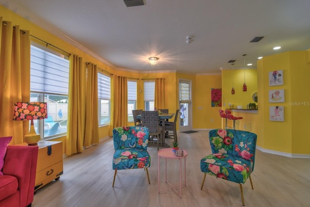 living area featuring light hardwood / wood-style flooring and crown molding