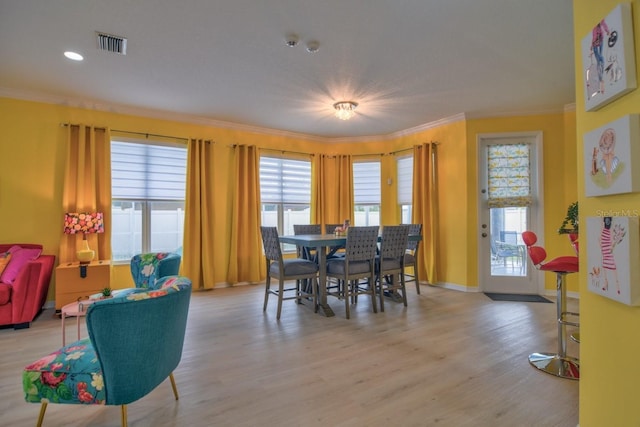 dining room featuring ornamental molding and light hardwood / wood-style floors