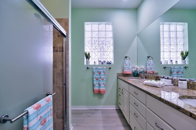 bathroom featuring hardwood / wood-style flooring, plenty of natural light, and a shower with shower door