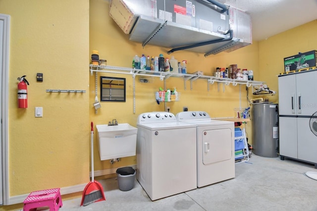 washroom featuring electric water heater, sink, and washer and dryer