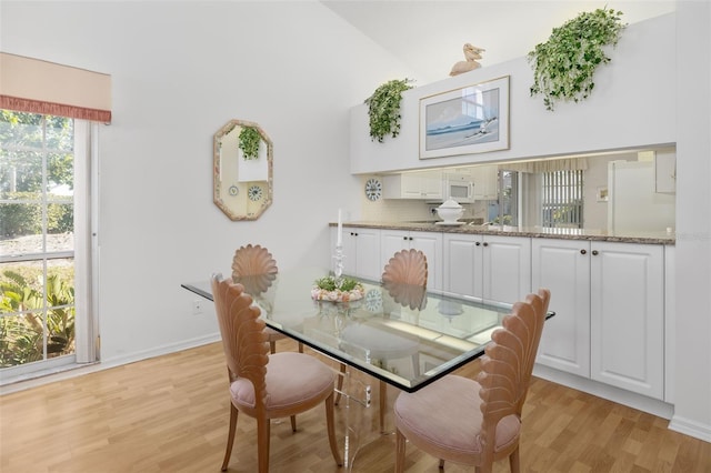 dining area featuring lofted ceiling and light hardwood / wood-style flooring