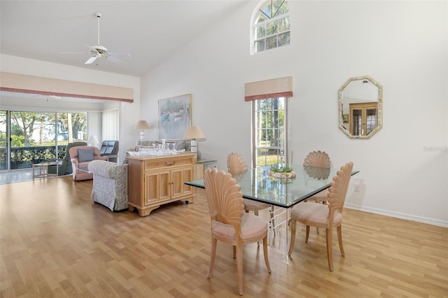 dining space featuring ceiling fan, high vaulted ceiling, and light hardwood / wood-style flooring