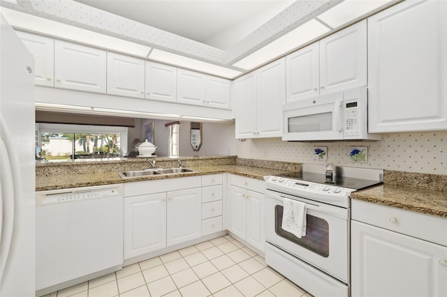 kitchen featuring white appliances, dark stone countertops, sink, and white cabinets