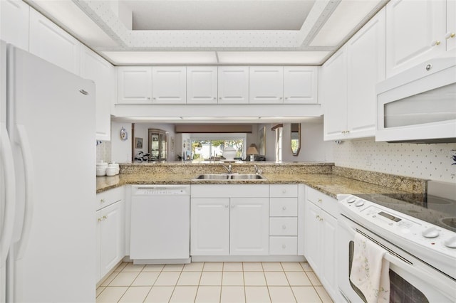 kitchen with light tile patterned flooring, sink, white cabinets, kitchen peninsula, and white appliances