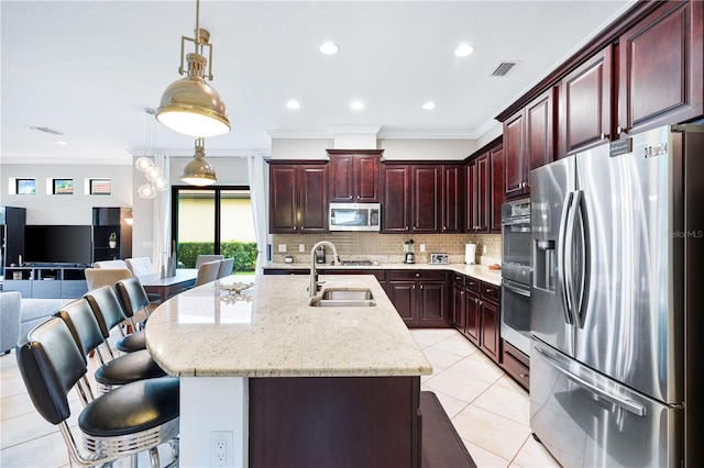 kitchen featuring sink, ornamental molding, stainless steel appliances, and a breakfast bar