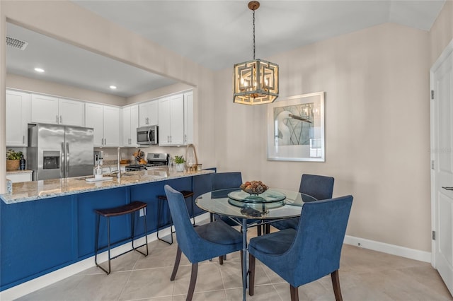 tiled dining room with an inviting chandelier