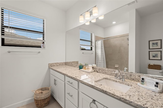 bathroom featuring toilet, tile patterned flooring, walk in shower, and vanity