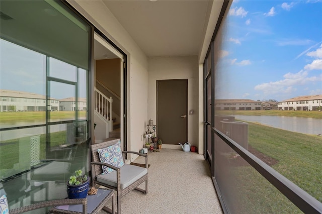 sunroom / solarium featuring a water view and a healthy amount of sunlight