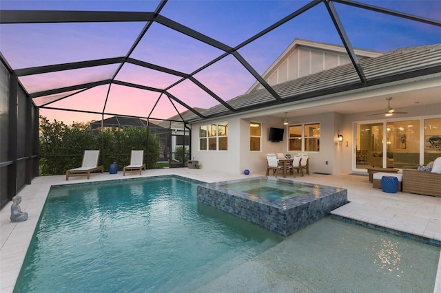 view of pool with glass enclosure, an in ground hot tub, a patio area, ceiling fan, and an outdoor hangout area