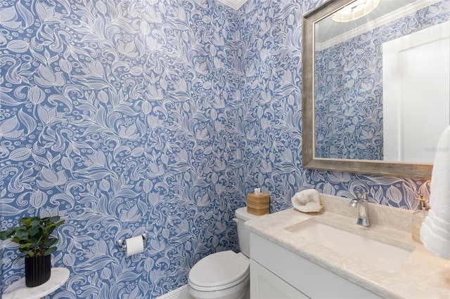 bathroom with vanity, toilet, and crown molding