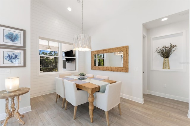 dining space featuring vaulted ceiling, a chandelier, and light hardwood / wood-style flooring