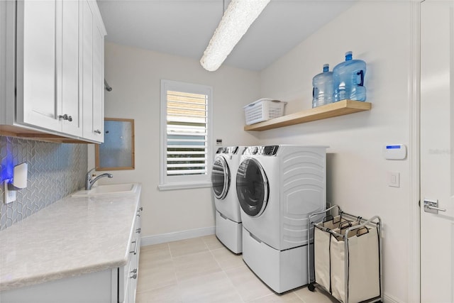 laundry area with sink, light tile patterned floors, cabinets, and washer and dryer