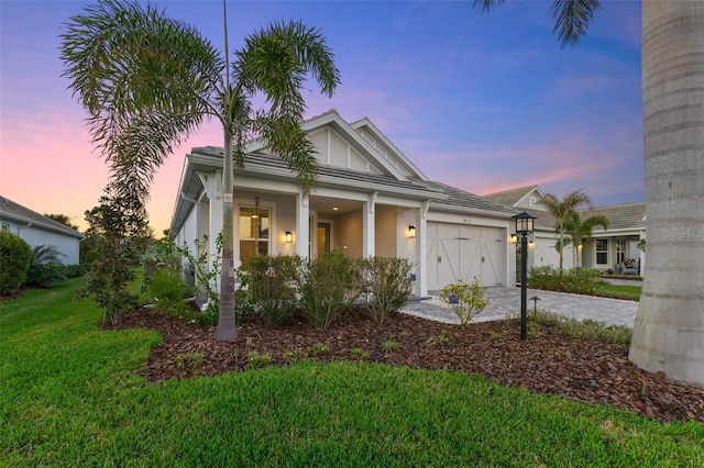 view of front of property with a garage and a yard