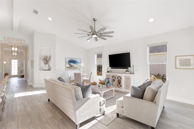 living room featuring light hardwood / wood-style floors, vaulted ceiling with beams, and ceiling fan