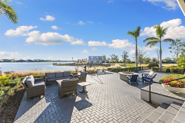 view of patio / terrace featuring a water view and an outdoor living space with a fire pit