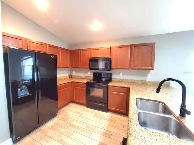 kitchen with black appliances, light stone countertops, sink, kitchen peninsula, and lofted ceiling