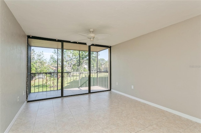 unfurnished room with ceiling fan and floor to ceiling windows