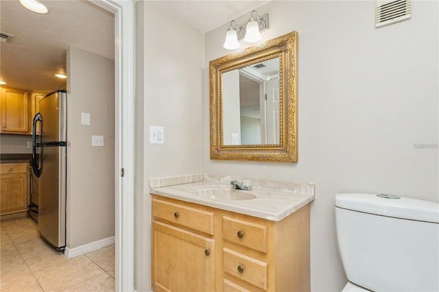 bathroom featuring toilet, tile patterned flooring, and vanity