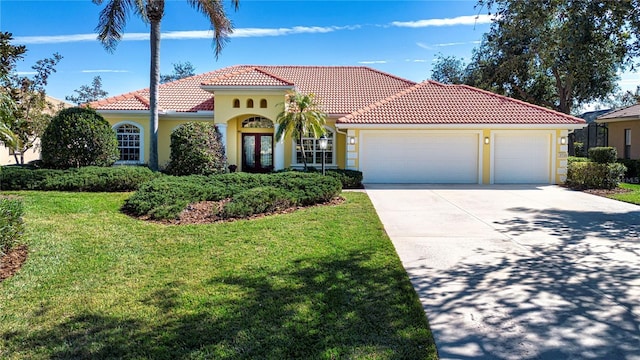 mediterranean / spanish-style home with a garage and a front yard