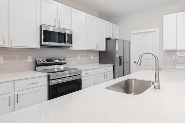 kitchen with white cabinets, stainless steel appliances, backsplash, and sink