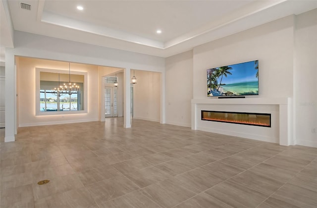 unfurnished living room featuring tile patterned flooring, a tray ceiling, and an inviting chandelier