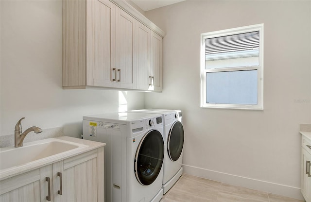 clothes washing area featuring cabinets, light tile patterned flooring, separate washer and dryer, and sink