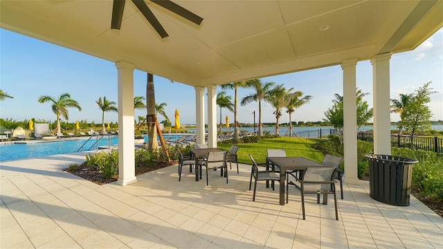 view of patio / terrace featuring a community pool, ceiling fan, and a water view