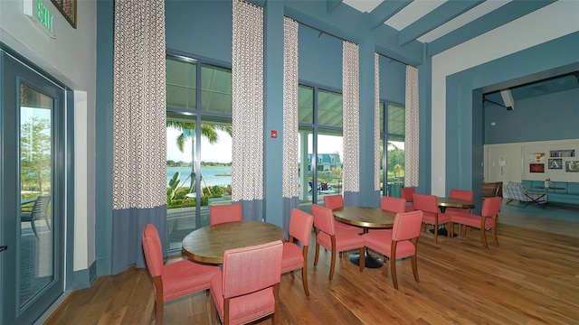 dining space with a water view and hardwood / wood-style floors