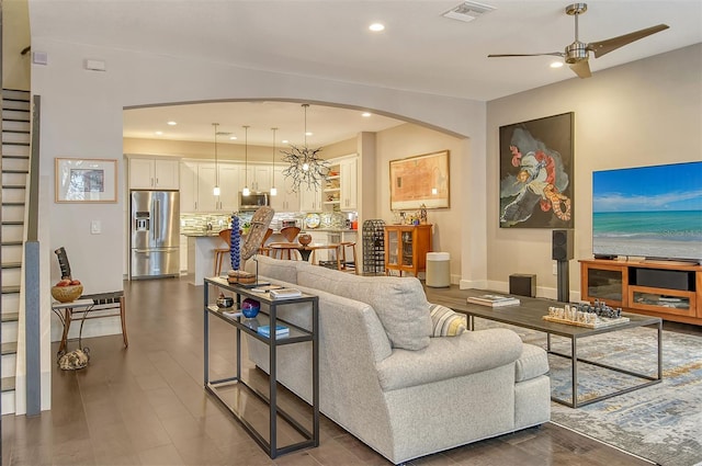 living room featuring ceiling fan and dark wood-type flooring