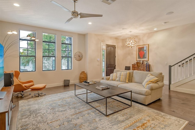 living room featuring hardwood / wood-style flooring and ceiling fan with notable chandelier