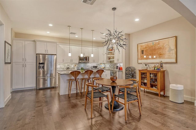 dining area featuring an inviting chandelier and wood-type flooring