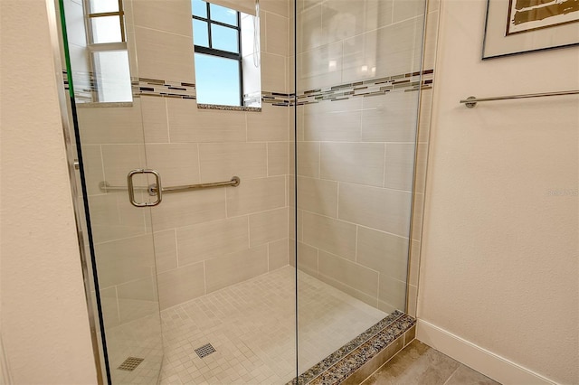 bathroom with tile patterned floors and a shower with door