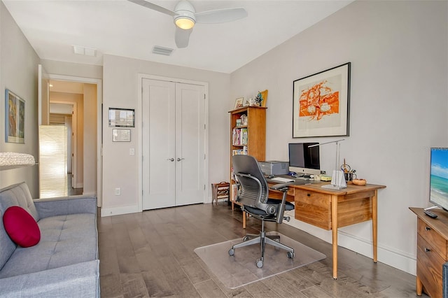 home office with ceiling fan and dark hardwood / wood-style flooring